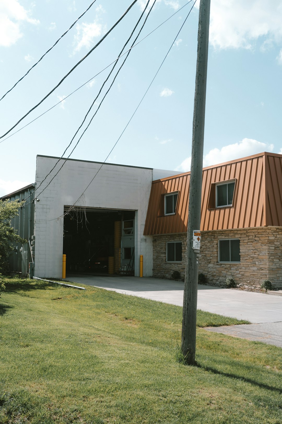 a-building-with-a-metal-roof-next-to-a-street-tgce2gdjamq